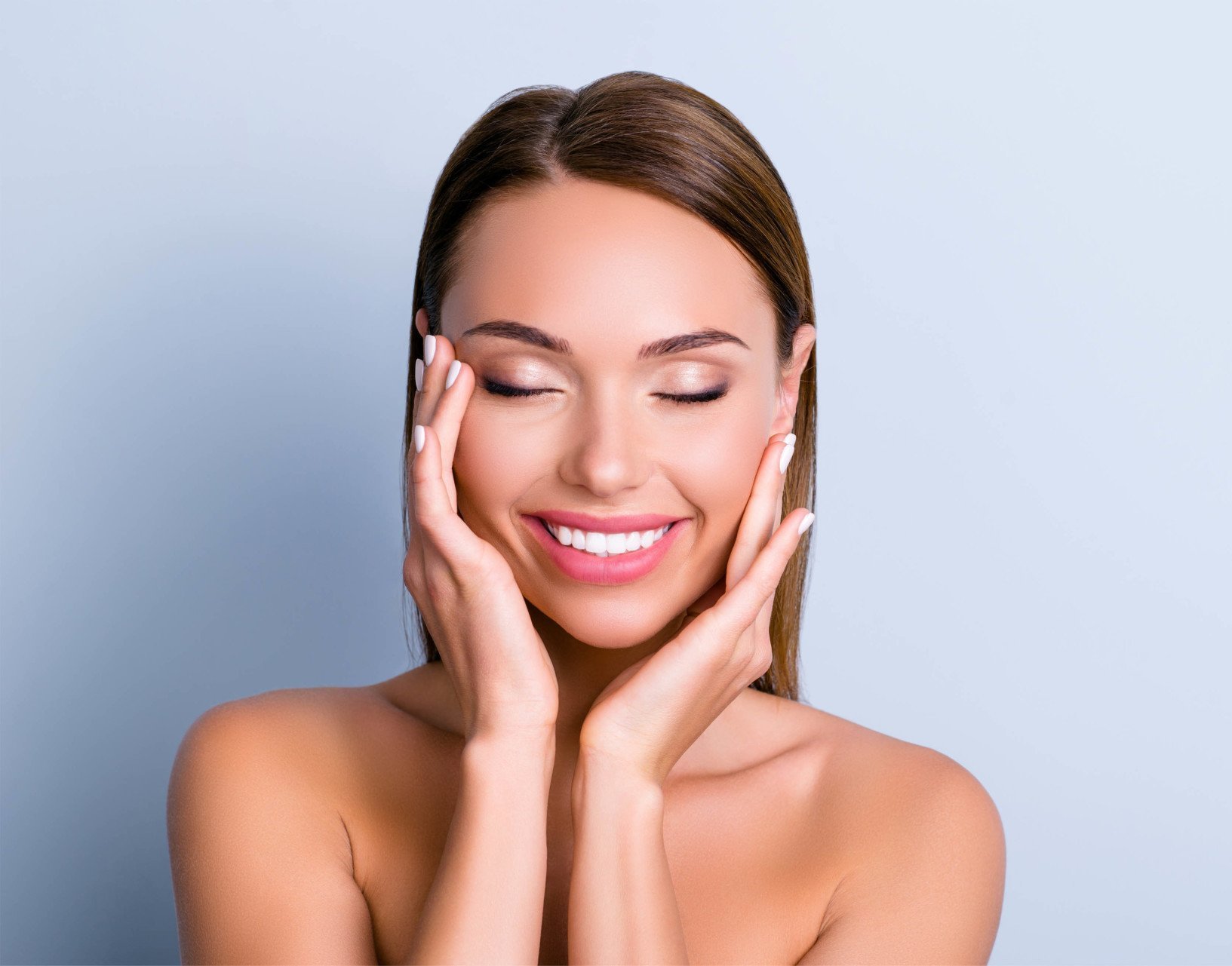 woman feeling skin and smiling after microneedling treatment