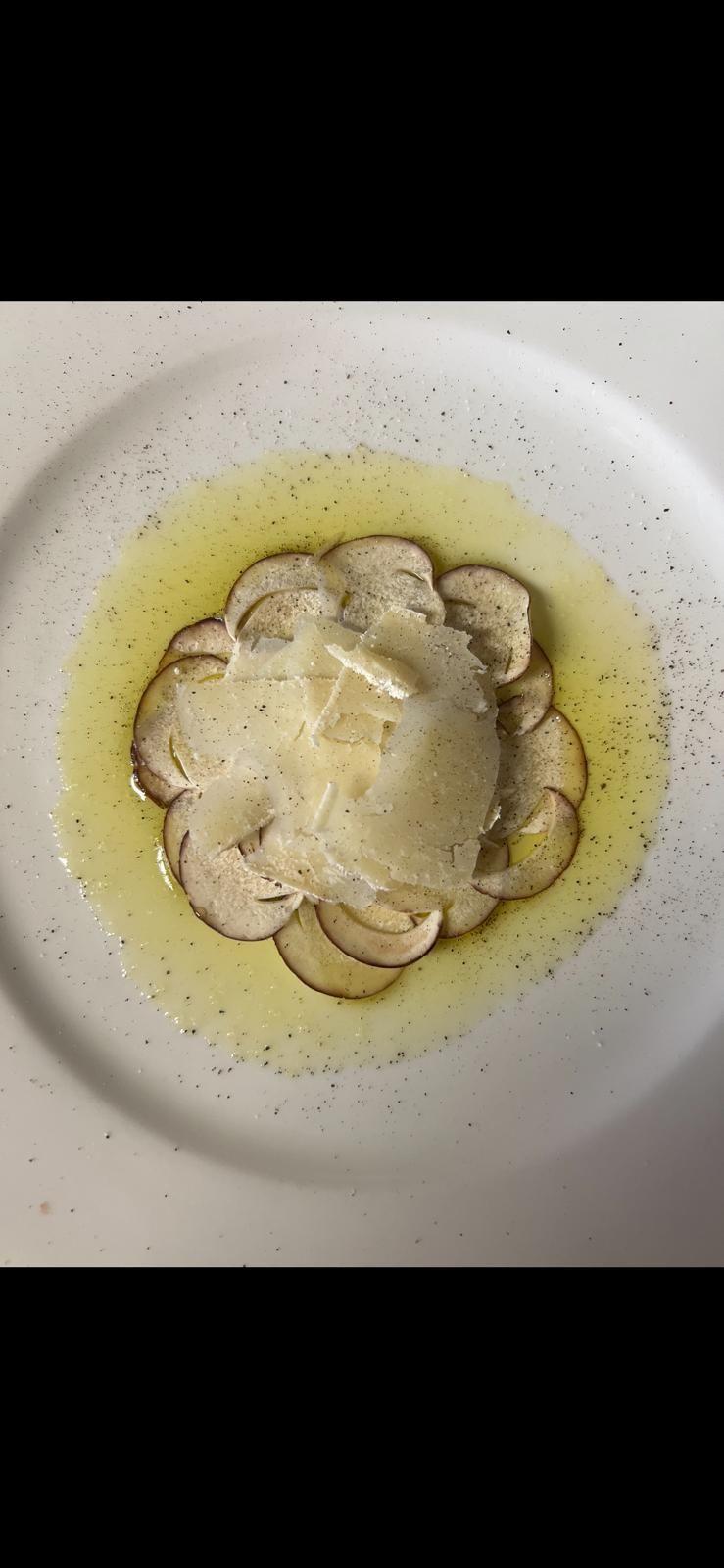 Un piatto bianco guarnito con funghi affettati e una salsa.