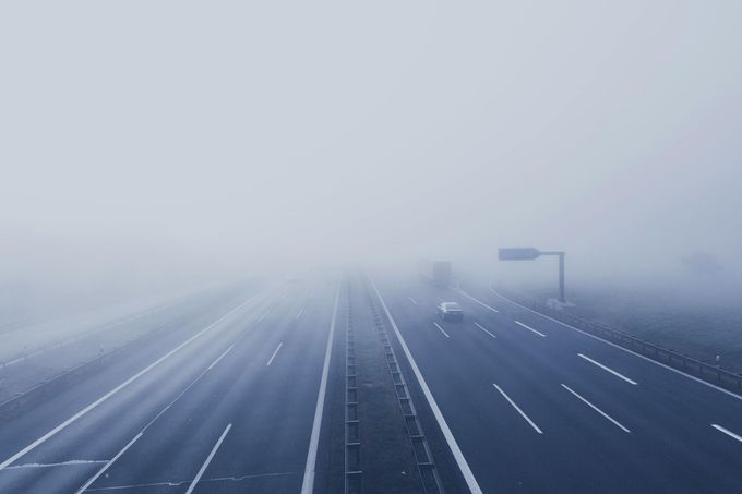 An aerial view of a highway in the fog.