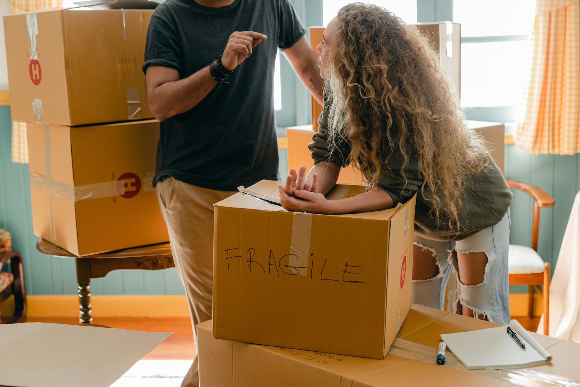 A man and a woman are standing next to a cardboard box.