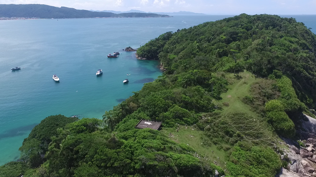 Uma vista aérea de uma pequena ilha no meio do oceano cercada por árvores.