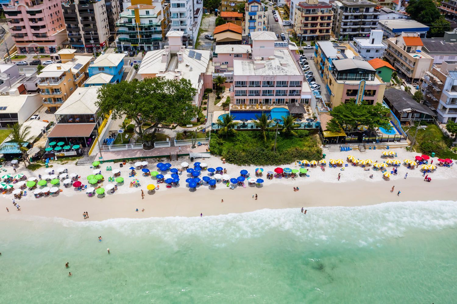 Uma vista aérea de uma praia cheia de pessoas e guarda-sóis