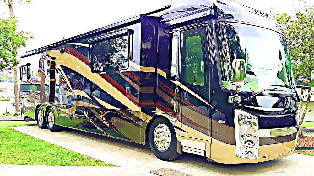 Large, luxurious RV parked on a grassy area, featuring a sleek design with gold, black, and red accents.