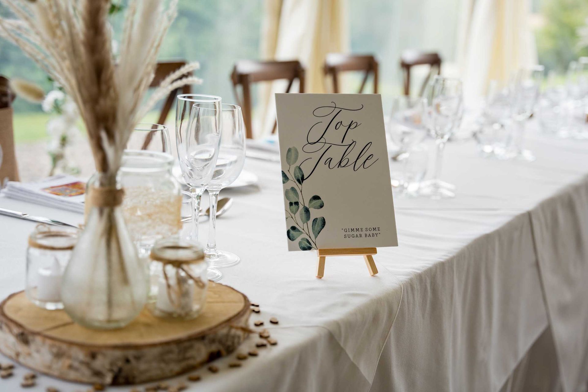 A table set for a wedding reception with a for table sign on it.