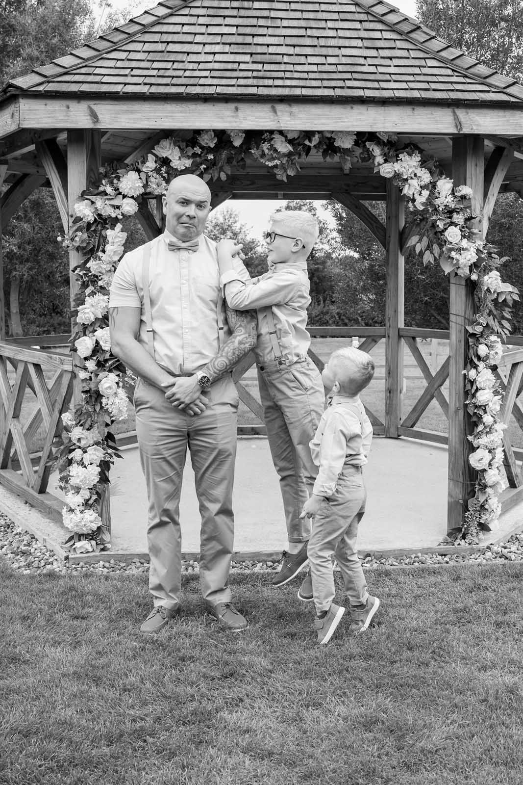 A black and white photo of a family standing in front of a gazebo.