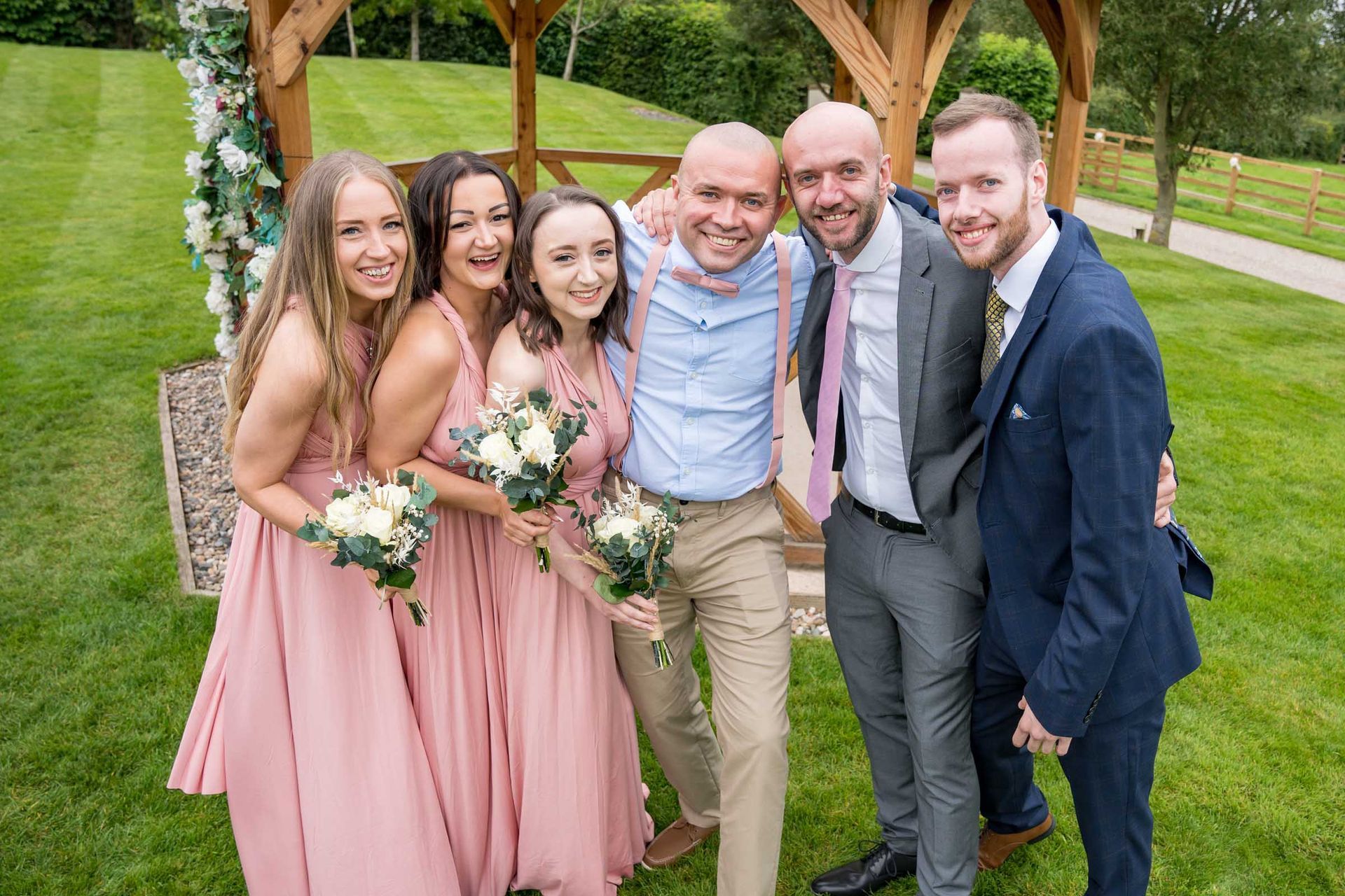 A group of people posing for a picture in front of a gazebo.