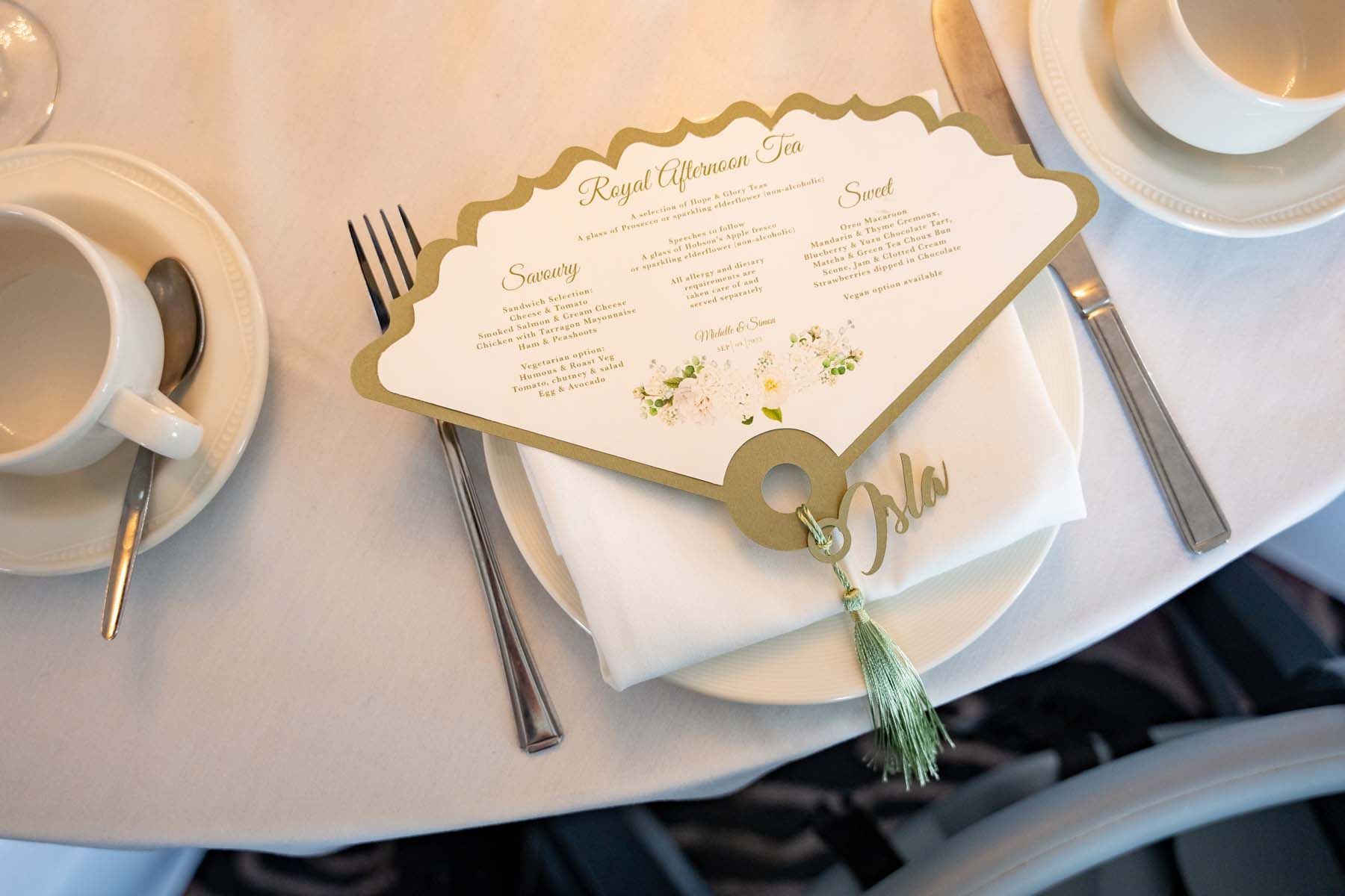 A fan shaped menu is sitting on a plate on a table.