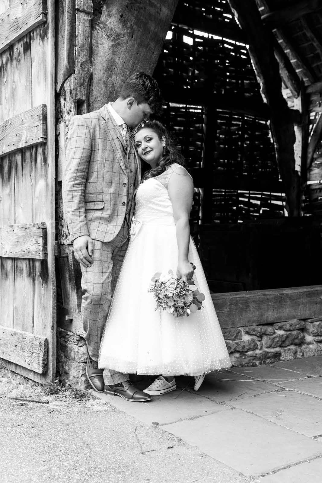 A black and white photo of a bride and groom standing next to each other.