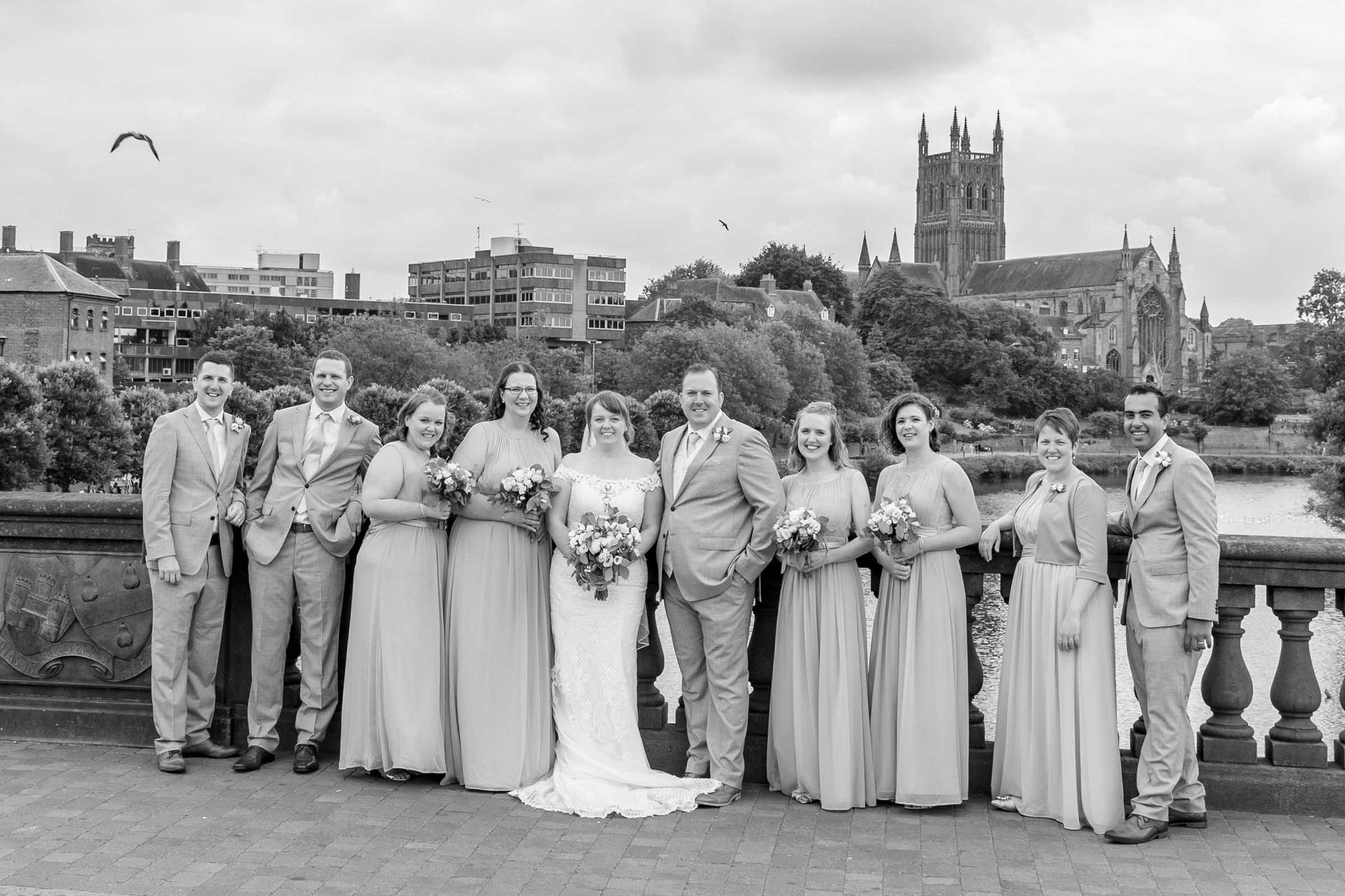A black and white photo of a wedding party posing for a picture.