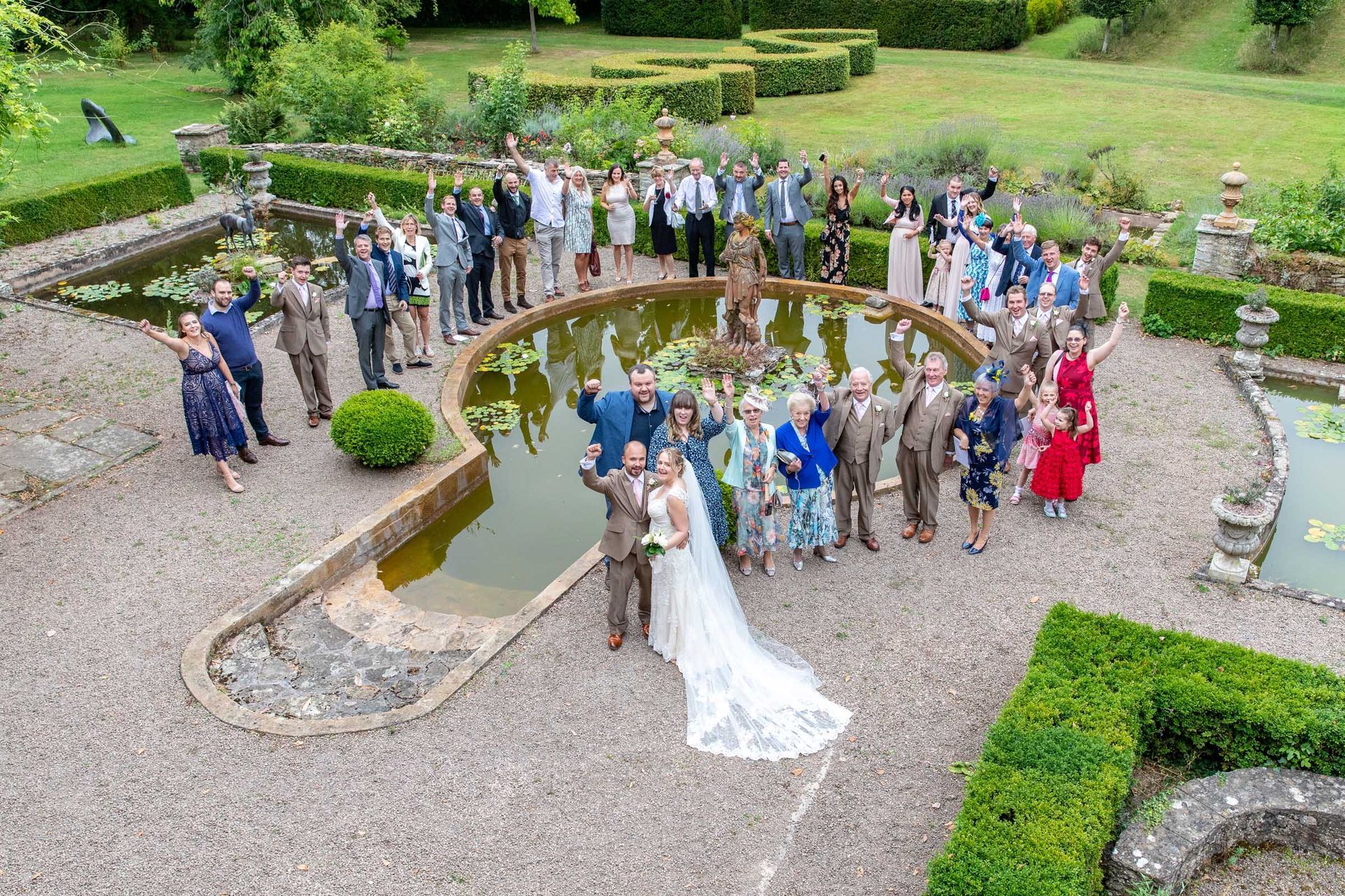 A large group of people are posing for a picture in front of a pond.