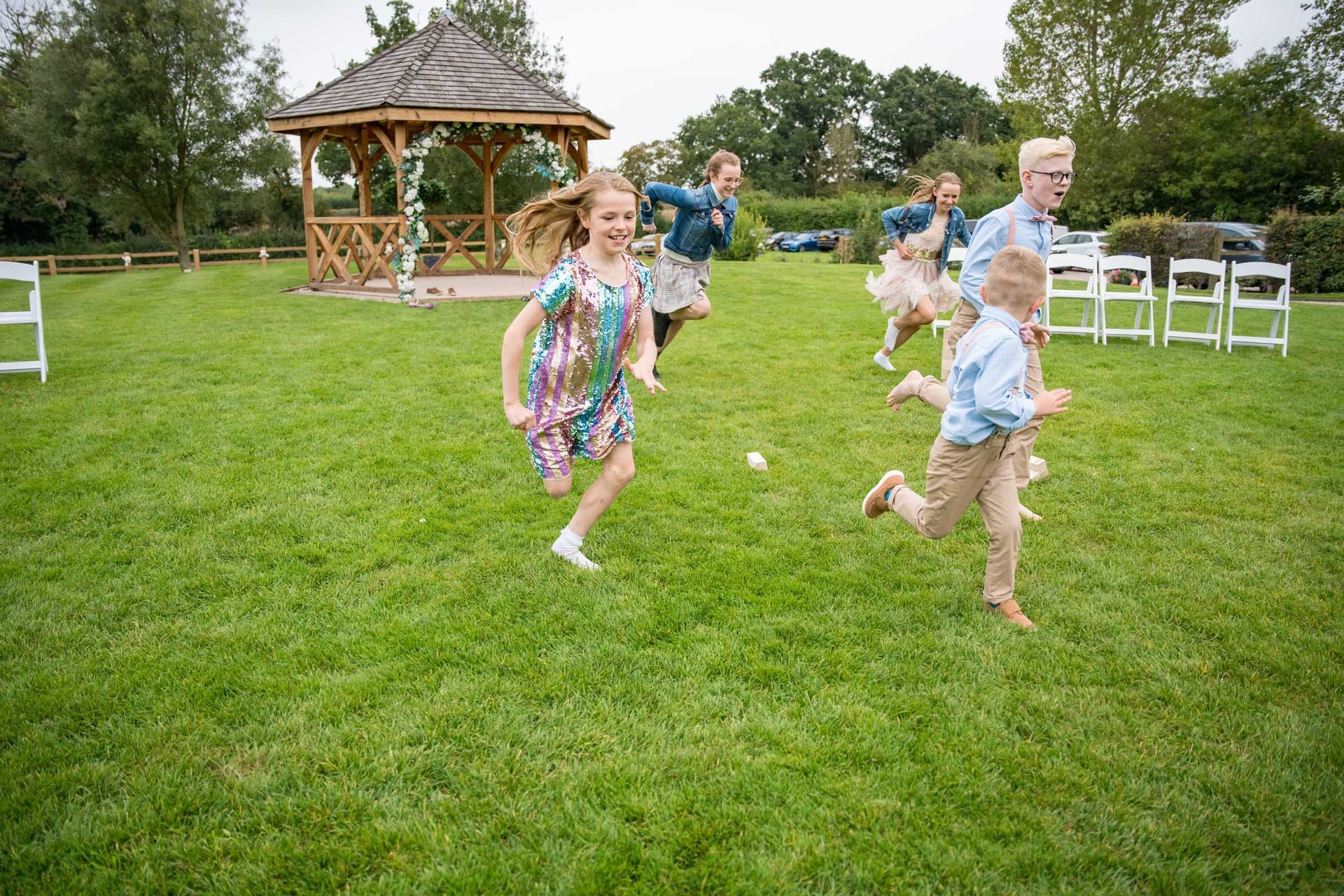 A group of children are running in a grassy field.