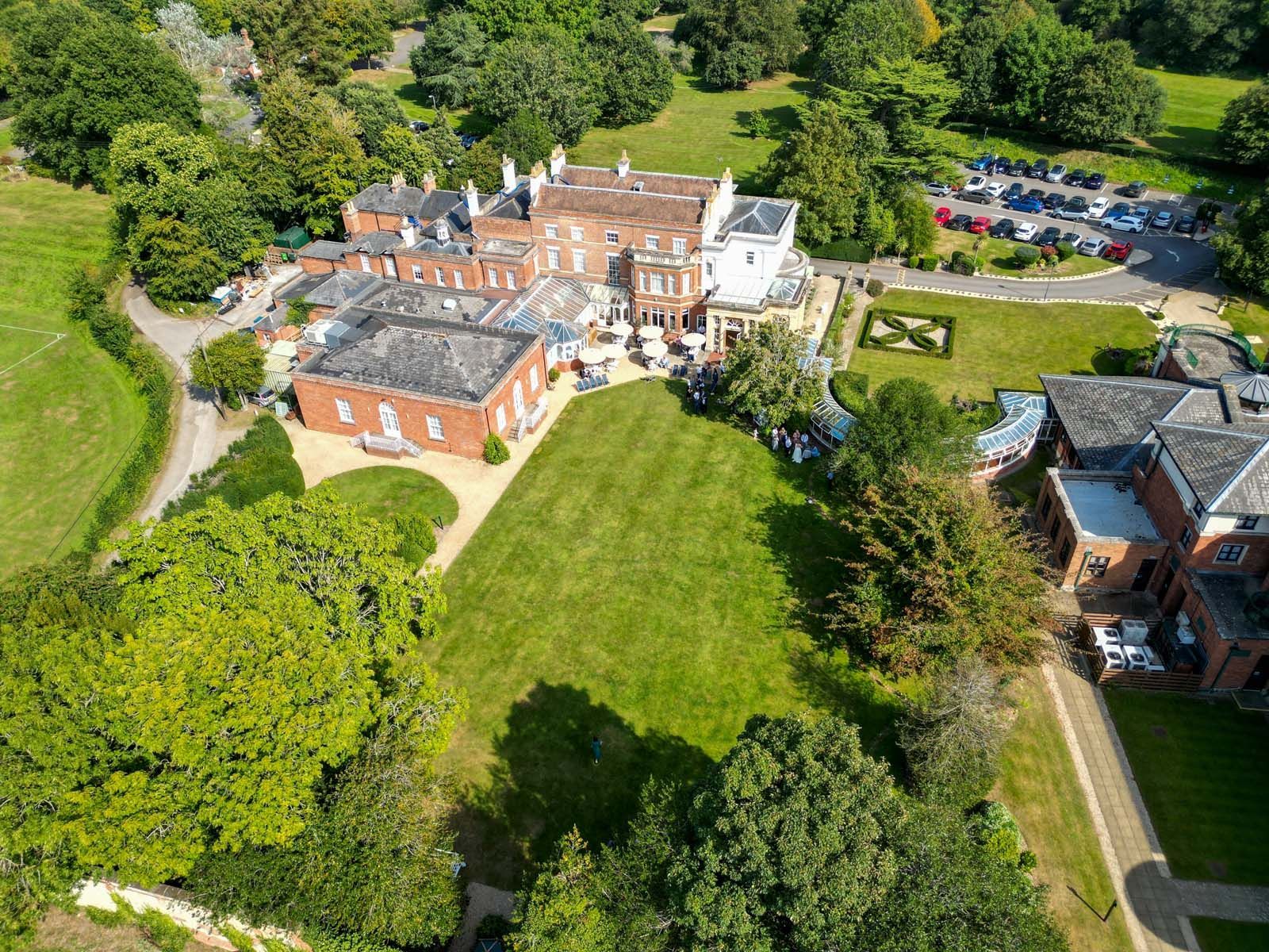 An aerial view of a large brick building surrounded by trees and grass.