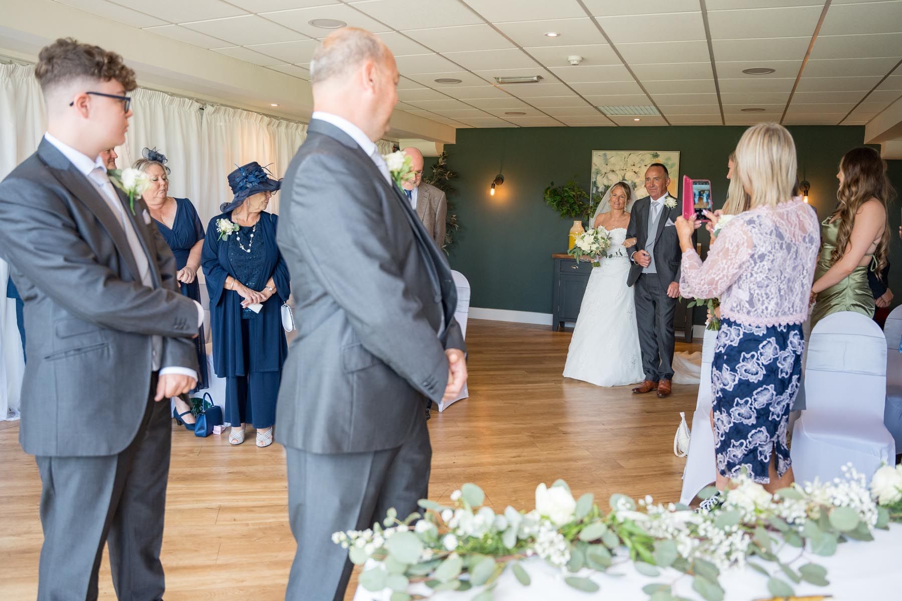 A bride and groom are walking down the aisle at a wedding ceremony.