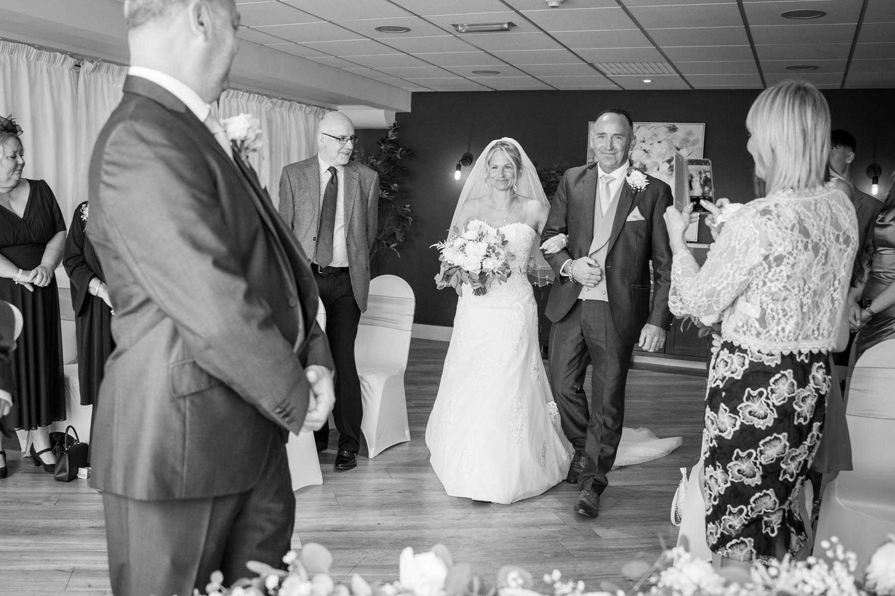 A bride and groom are walking down the aisle at a wedding ceremony.