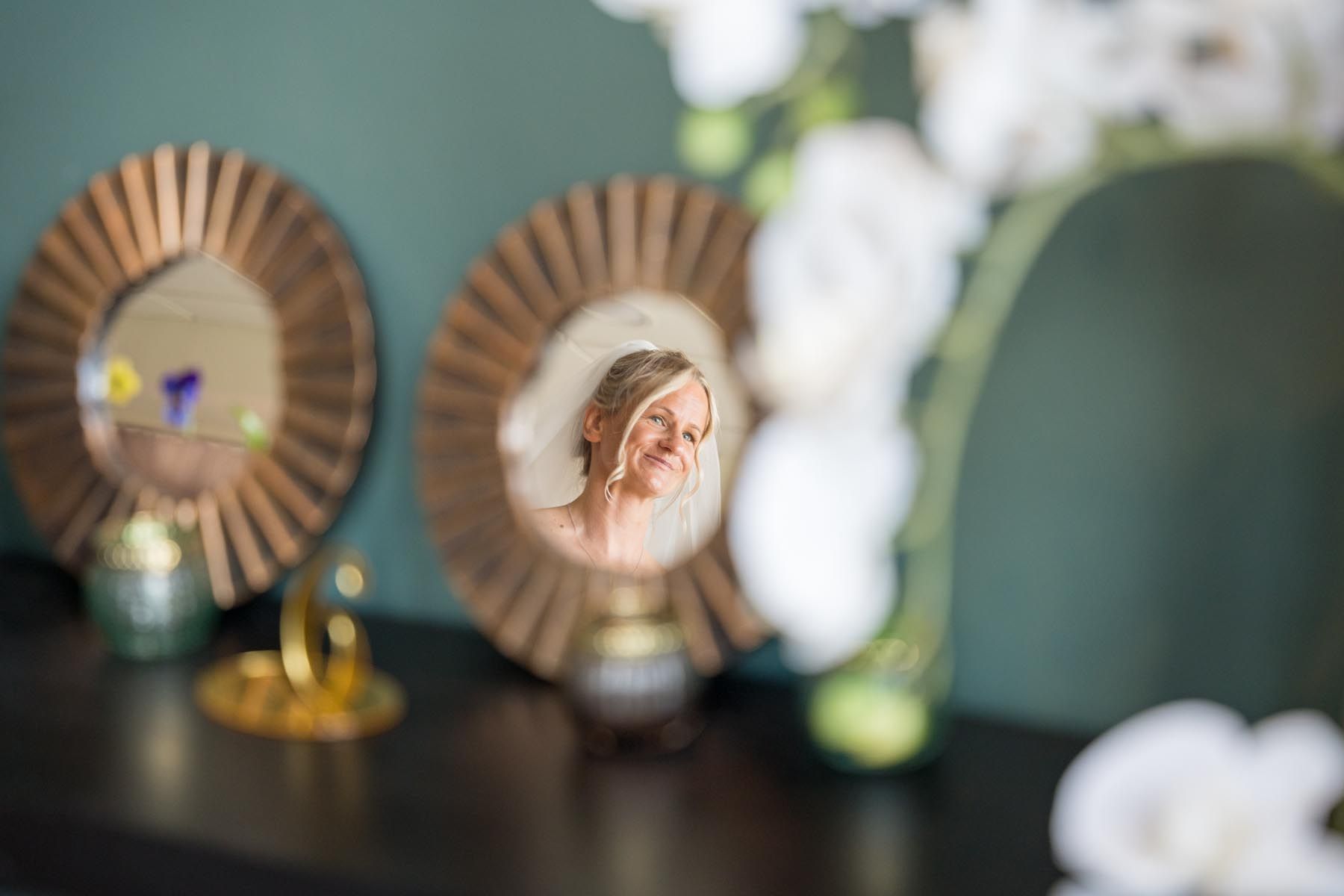 A woman is looking at herself in a mirror on a table.