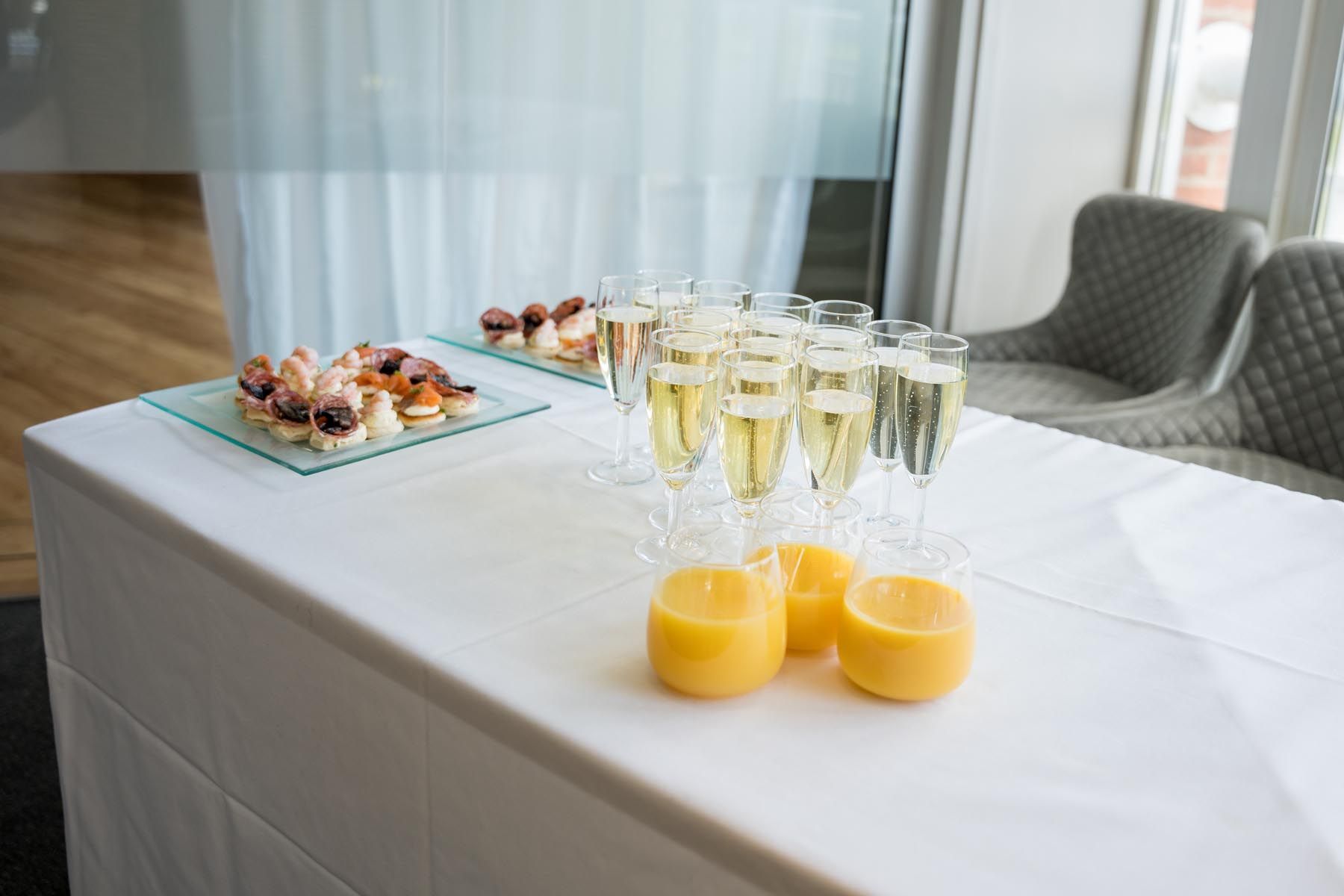 A table with glasses of champagne and orange juice on it.