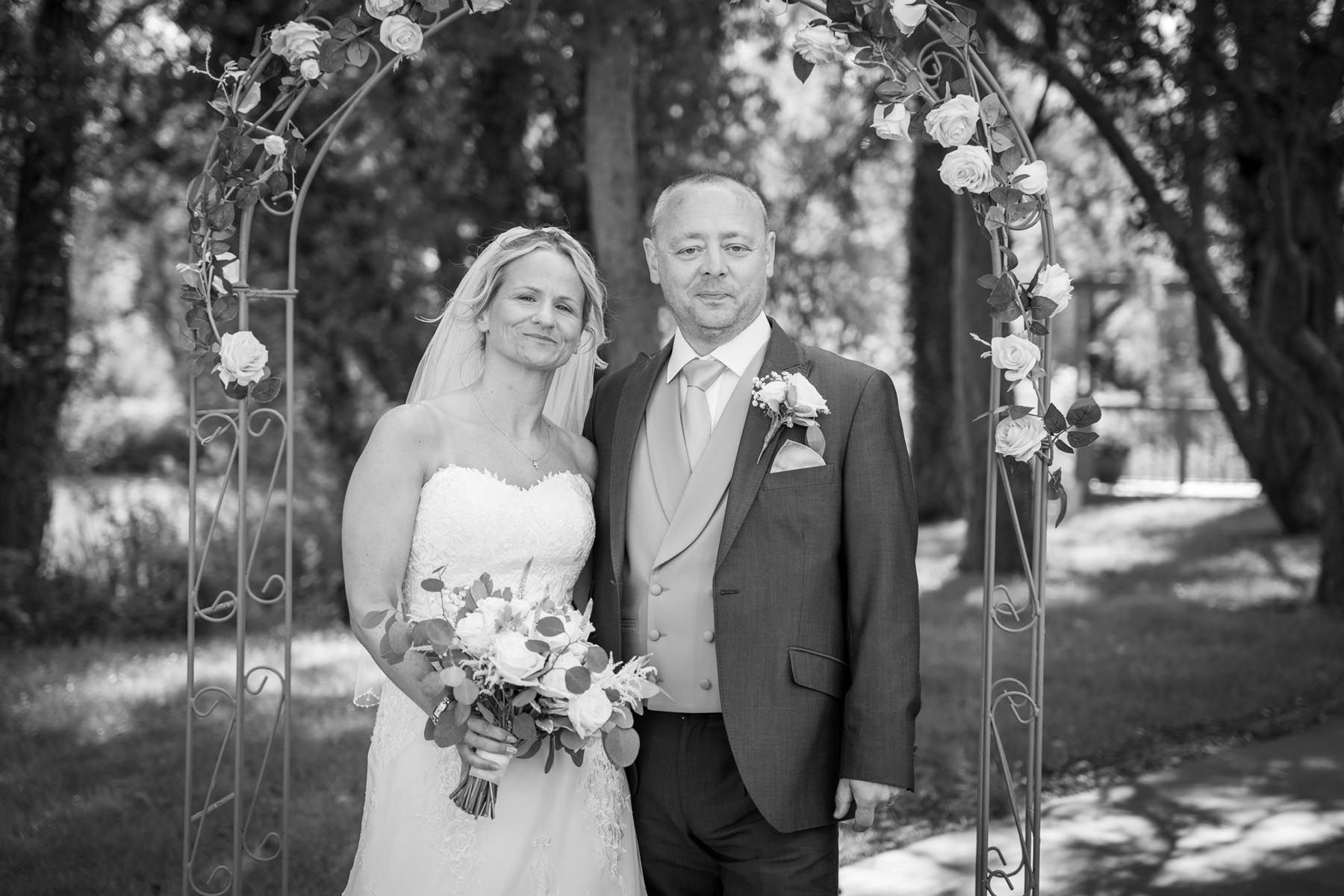 A black and white photo of a bride and groom posing for a picture.