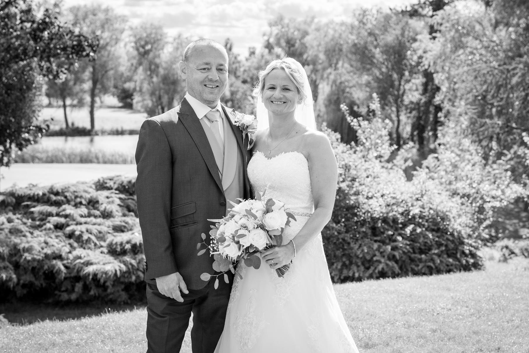 A black and white photo of a bride and groom posing for a picture.