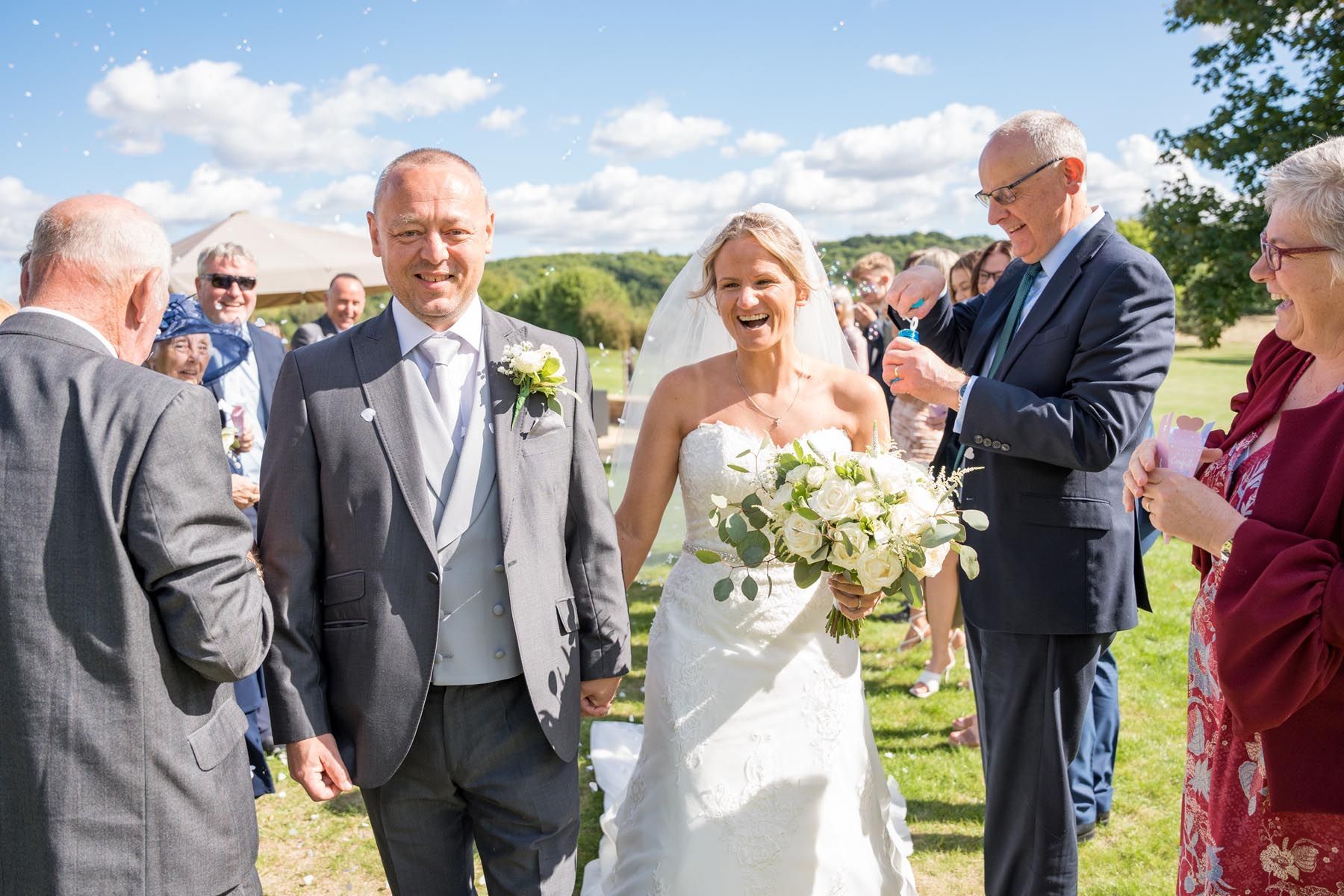 A bride and groom are walking down the aisle at their wedding.
