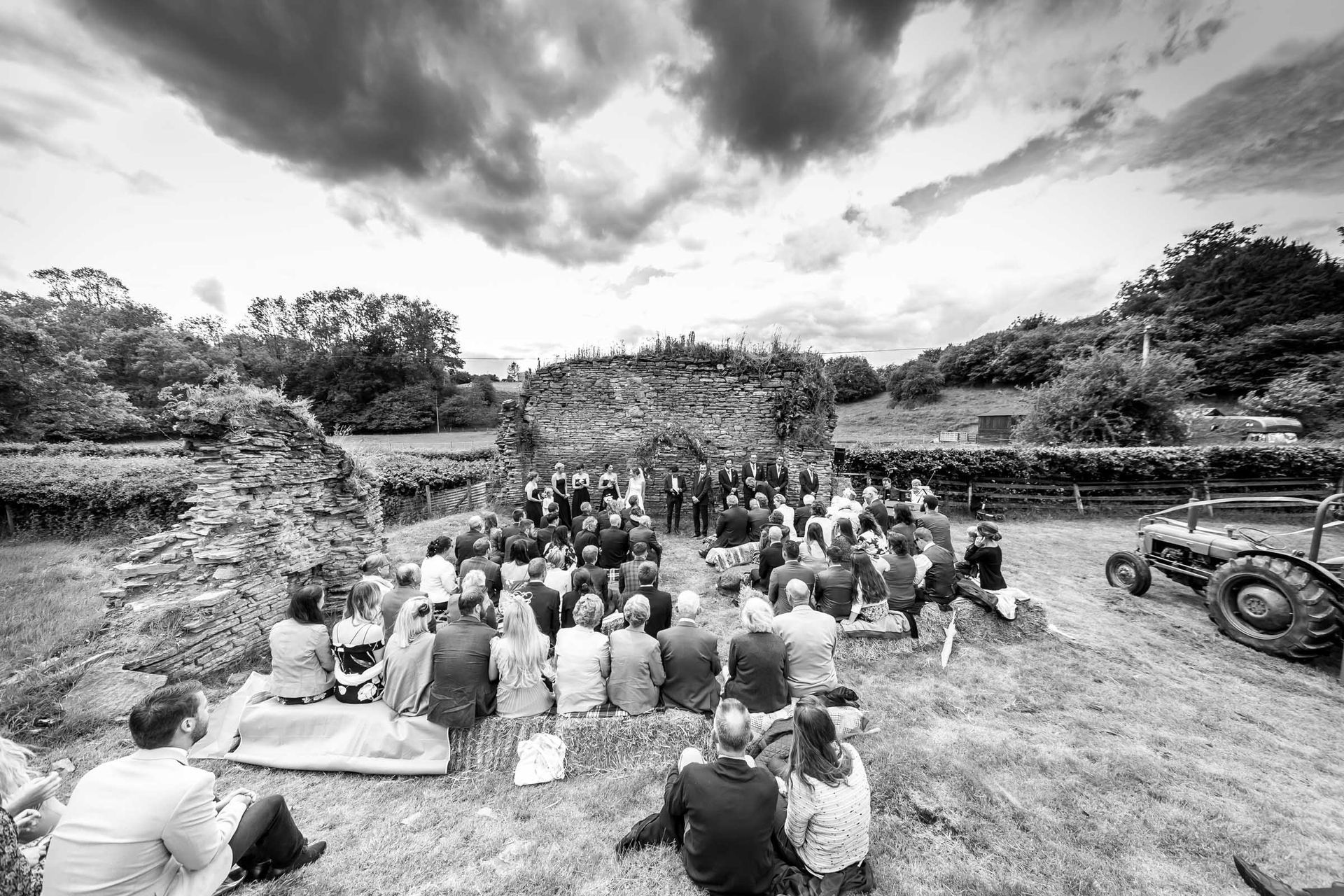 A black and white photo of a group of people sitting in the grass.