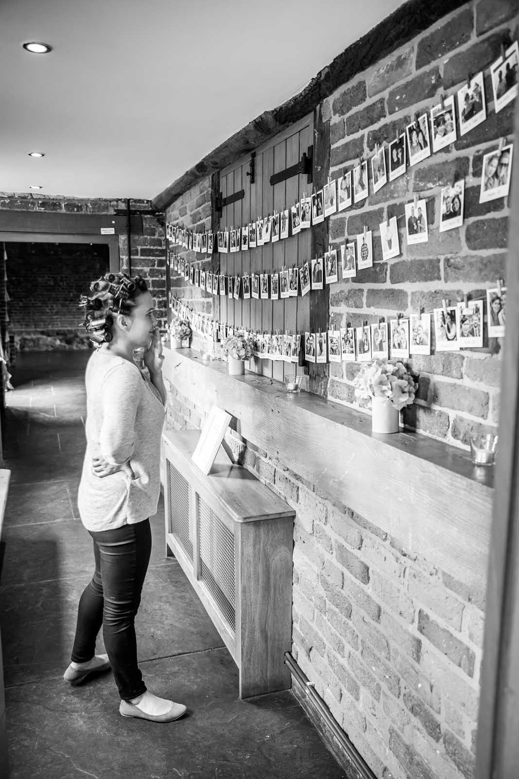 A woman is standing in a hallway next to a brick wall.