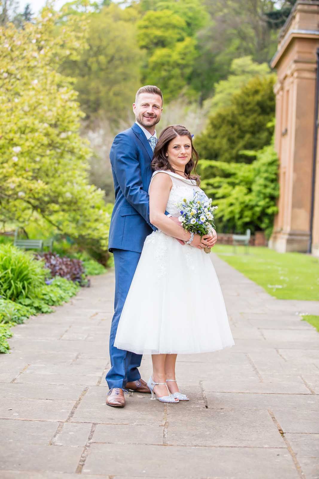 A bride and groom are posing for a picture on their wedding day.
