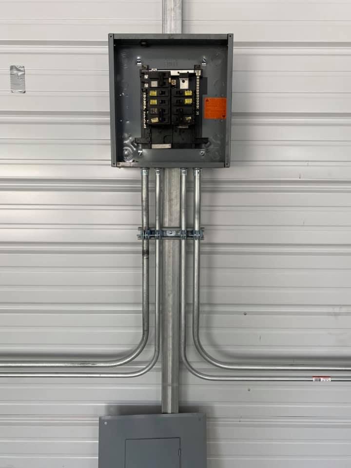 A electrical box is hanging on the side of a garage door.