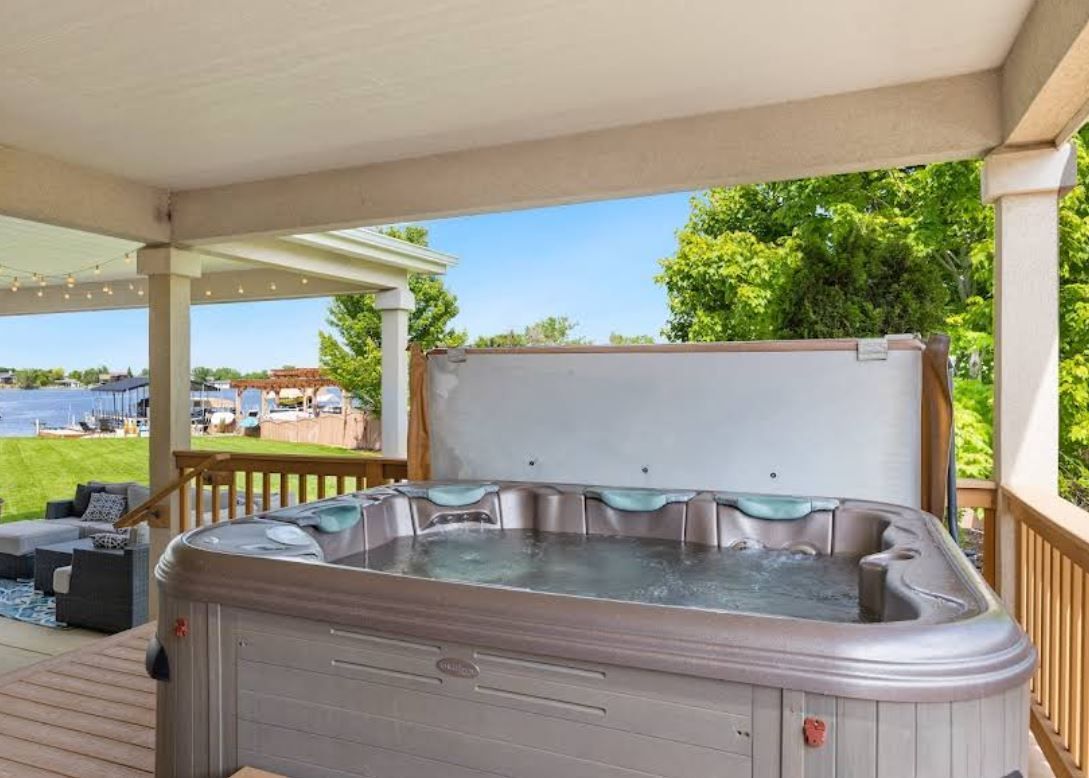 There is a hot tub on the deck of a house.