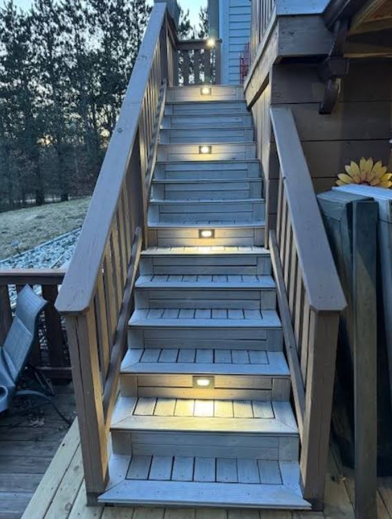 A set of stairs leading up to a deck with lights on them