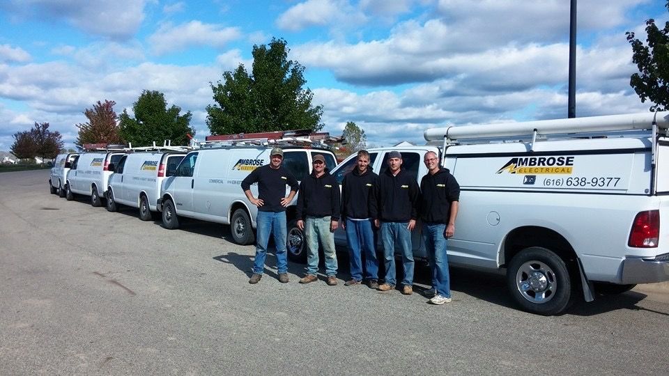 A group of men standing in front of a row of utility trucks