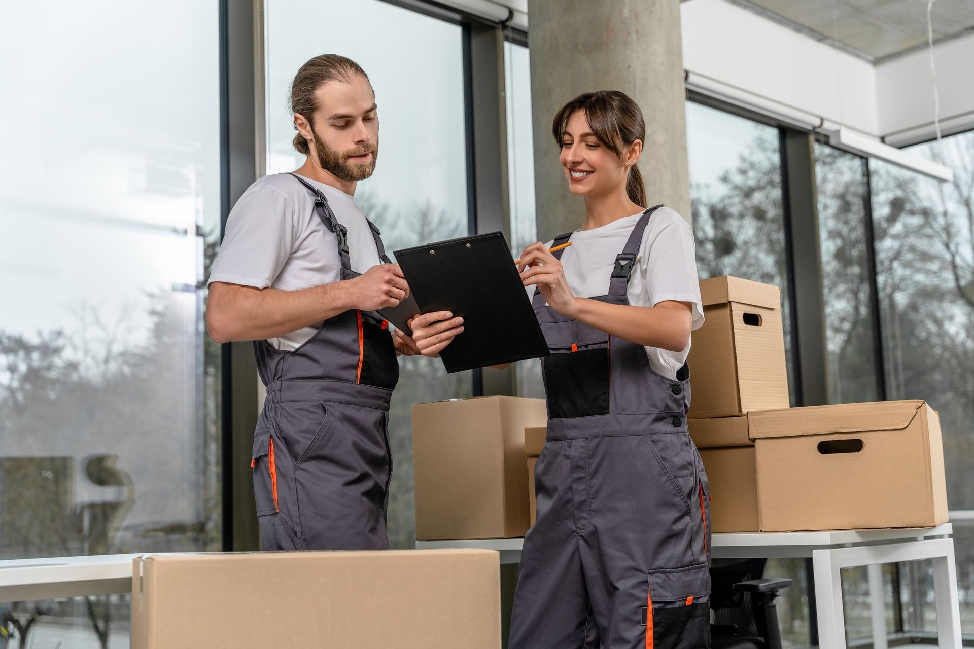 A man and a woman are standing next to each other looking at a clipboard.