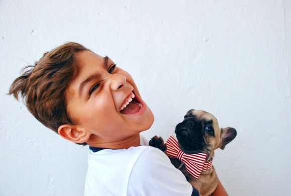 bambino che sorride con un cucciolo di cane