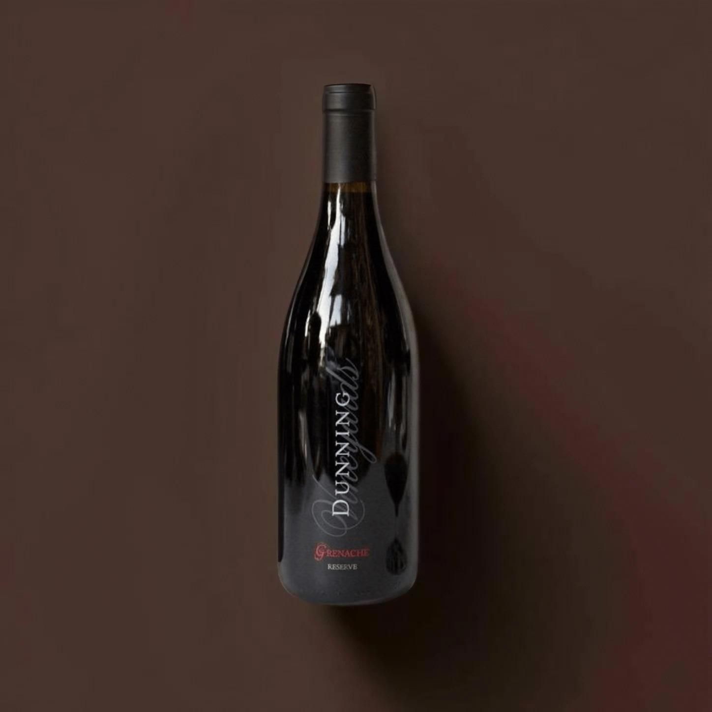A bottle of wine is sitting on a brown surface.