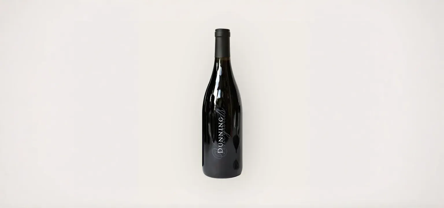 A bottle of wine is sitting on a white surface.
