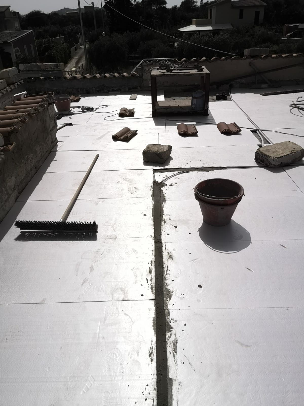 un pennello e un secchio sono sul tetto di un edificio in costruzione