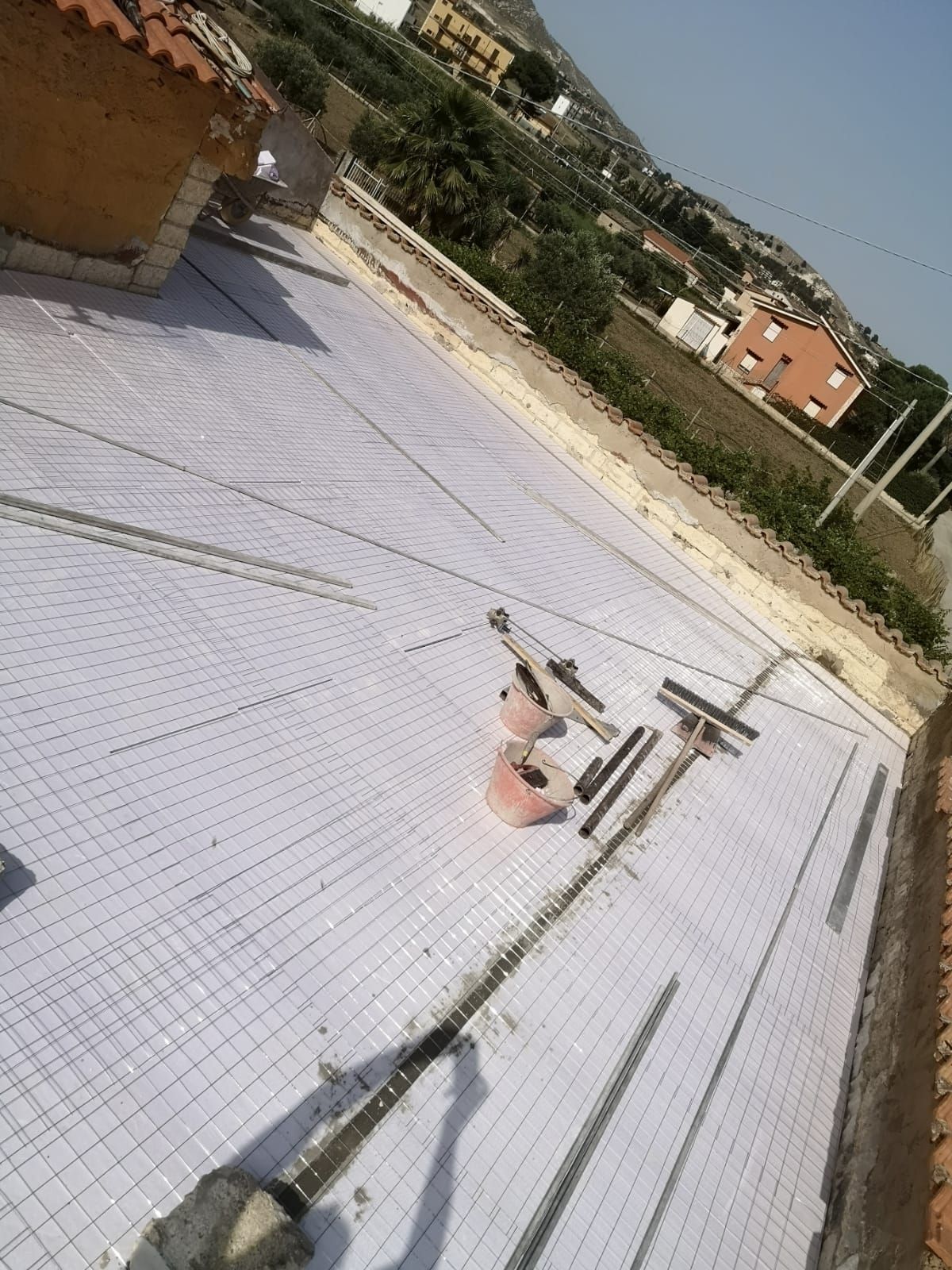 un edificio in costruzione con un tetto coperto di piastrelle bianche