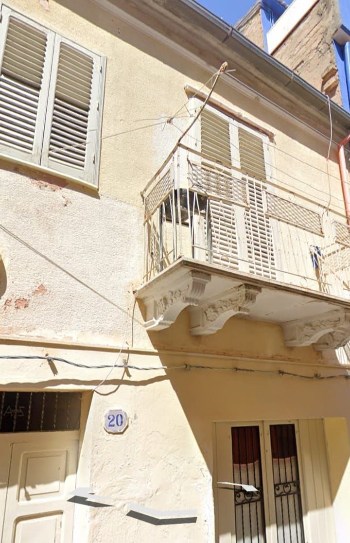 un edificio giallo con un balcone e il numero 20