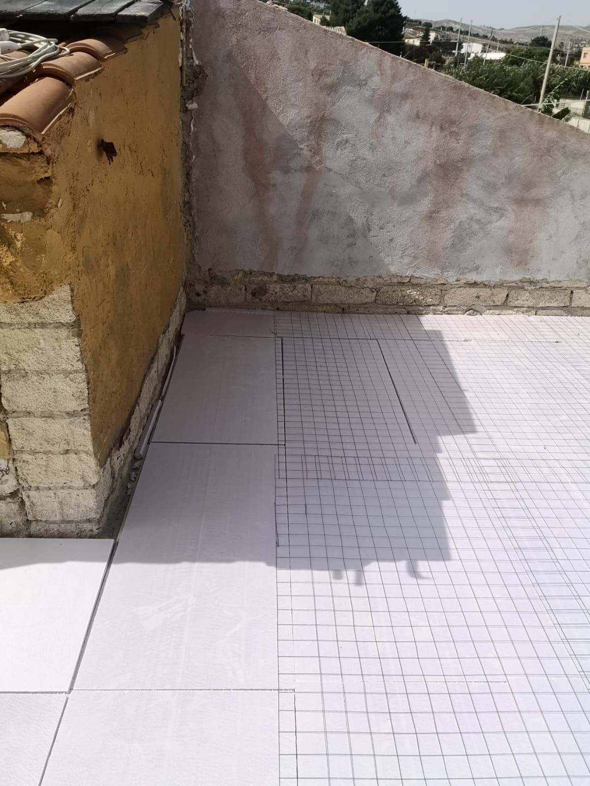 un pavimento di piastrelle bianche su un tetto di una casa