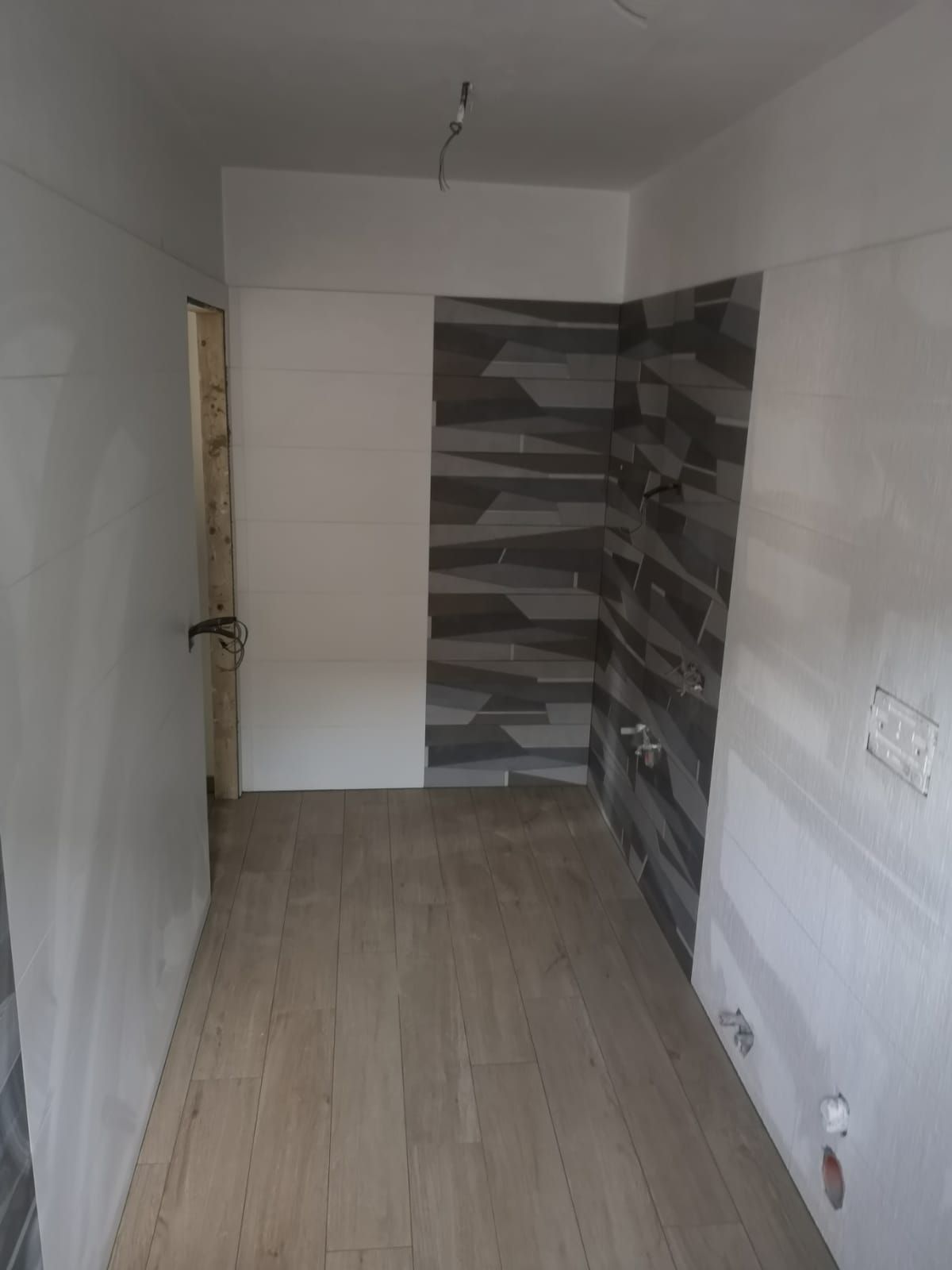 una stanza vuota con piastrelle bianche e grigie sulle pareti