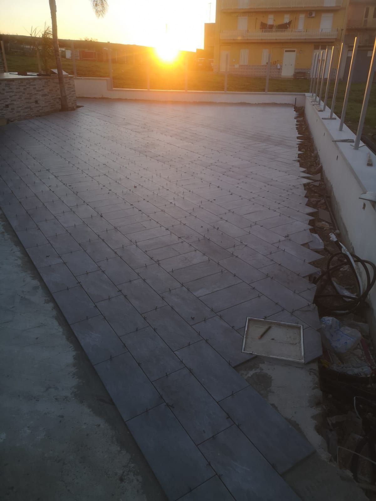un patio in costruzione con il sole che tramonta dietro