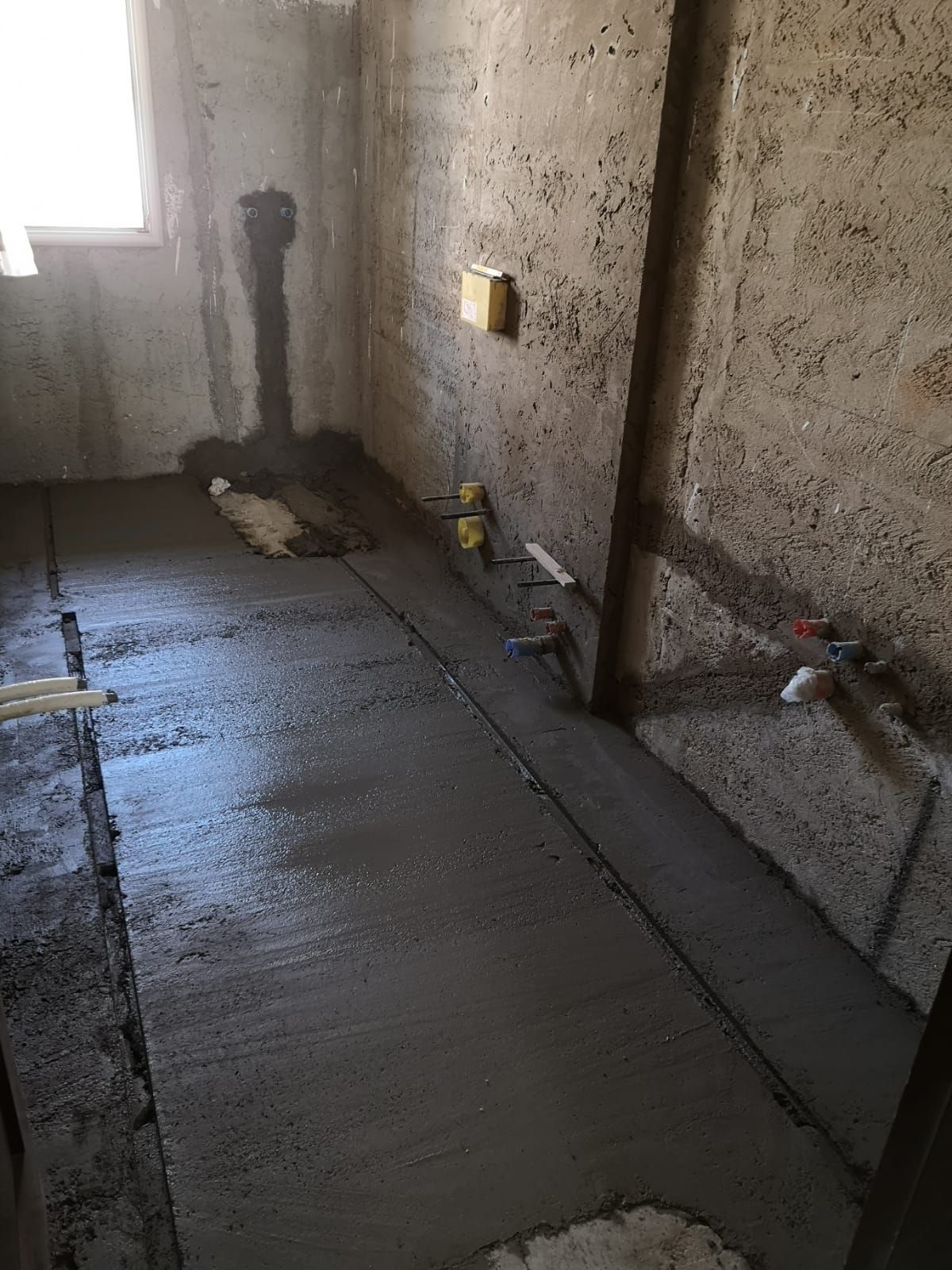 un bagno in costruzione con un pavimento di cemento