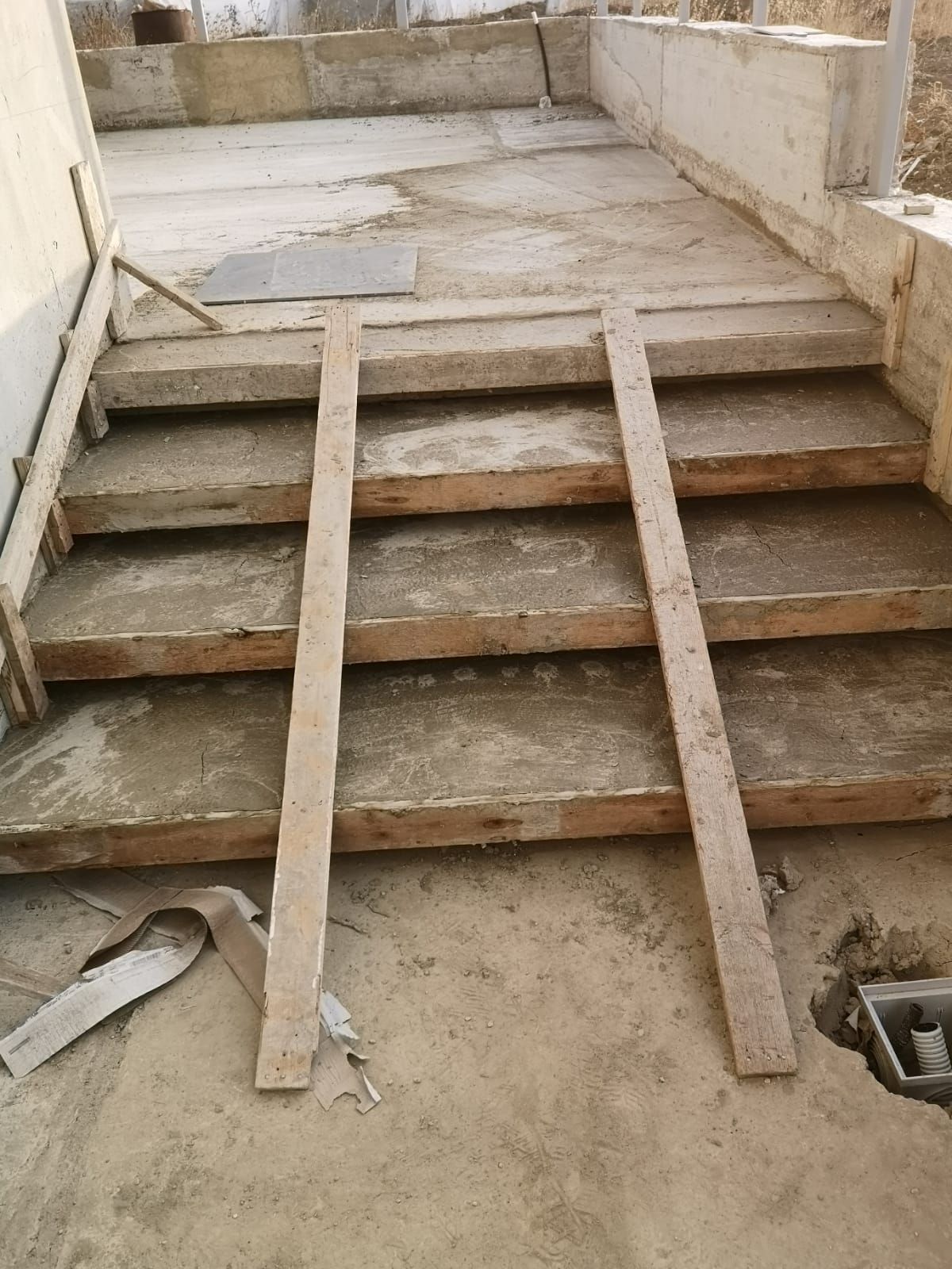 una rampa di legno è attaccata a un set di scale in cemento