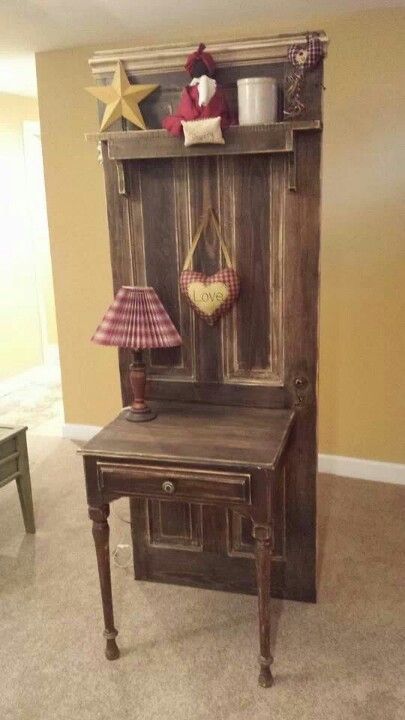 Rustic wooden hall tree with small table, lamp, and heart and star decorations against a beige wall