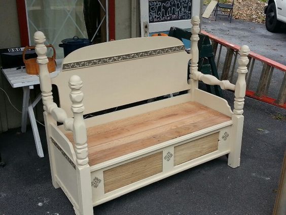 Cream-colored wooden bench with beige cushion and storage drawers, on an outdoor patio.
