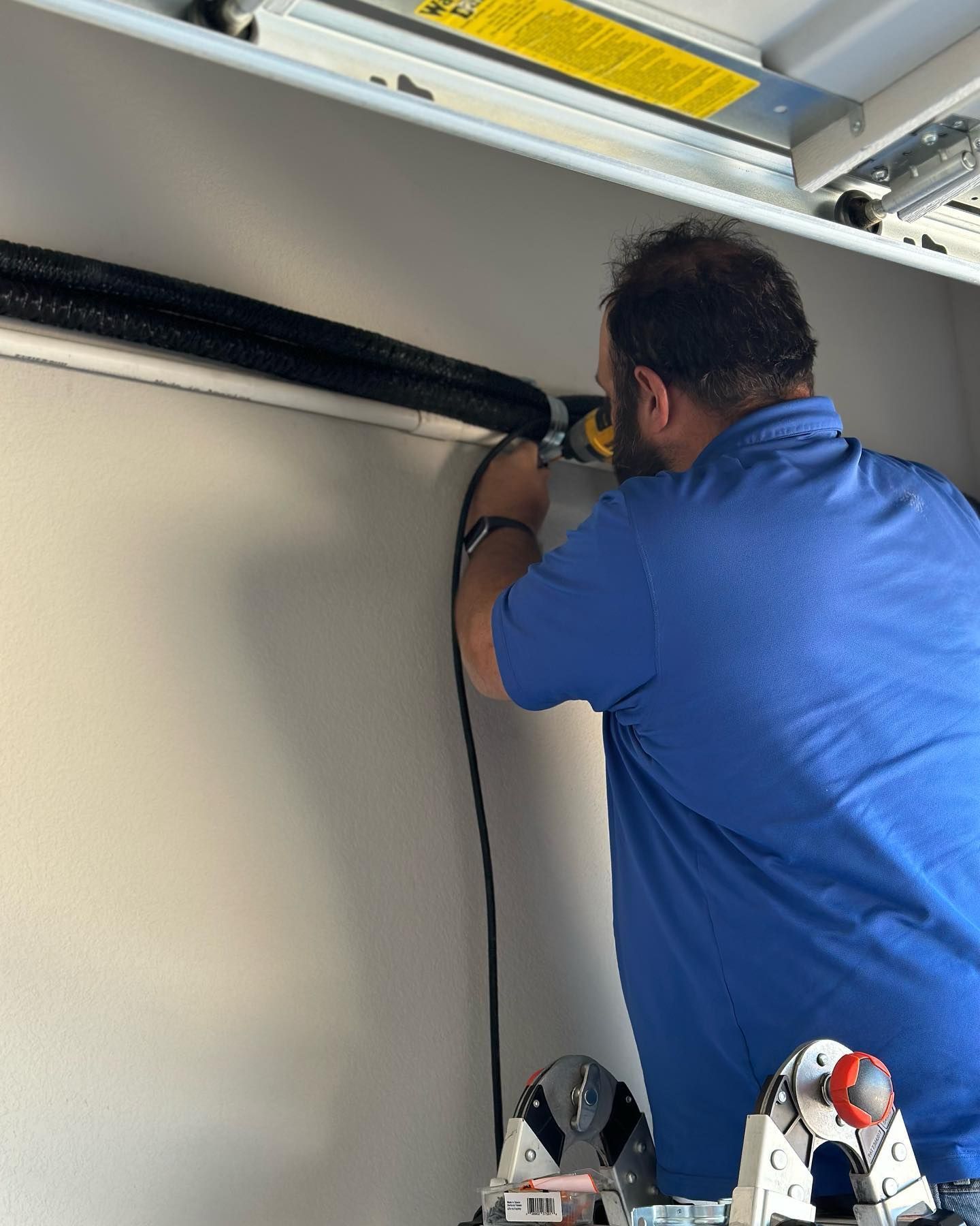 A man in a blue shirt is working on a wall