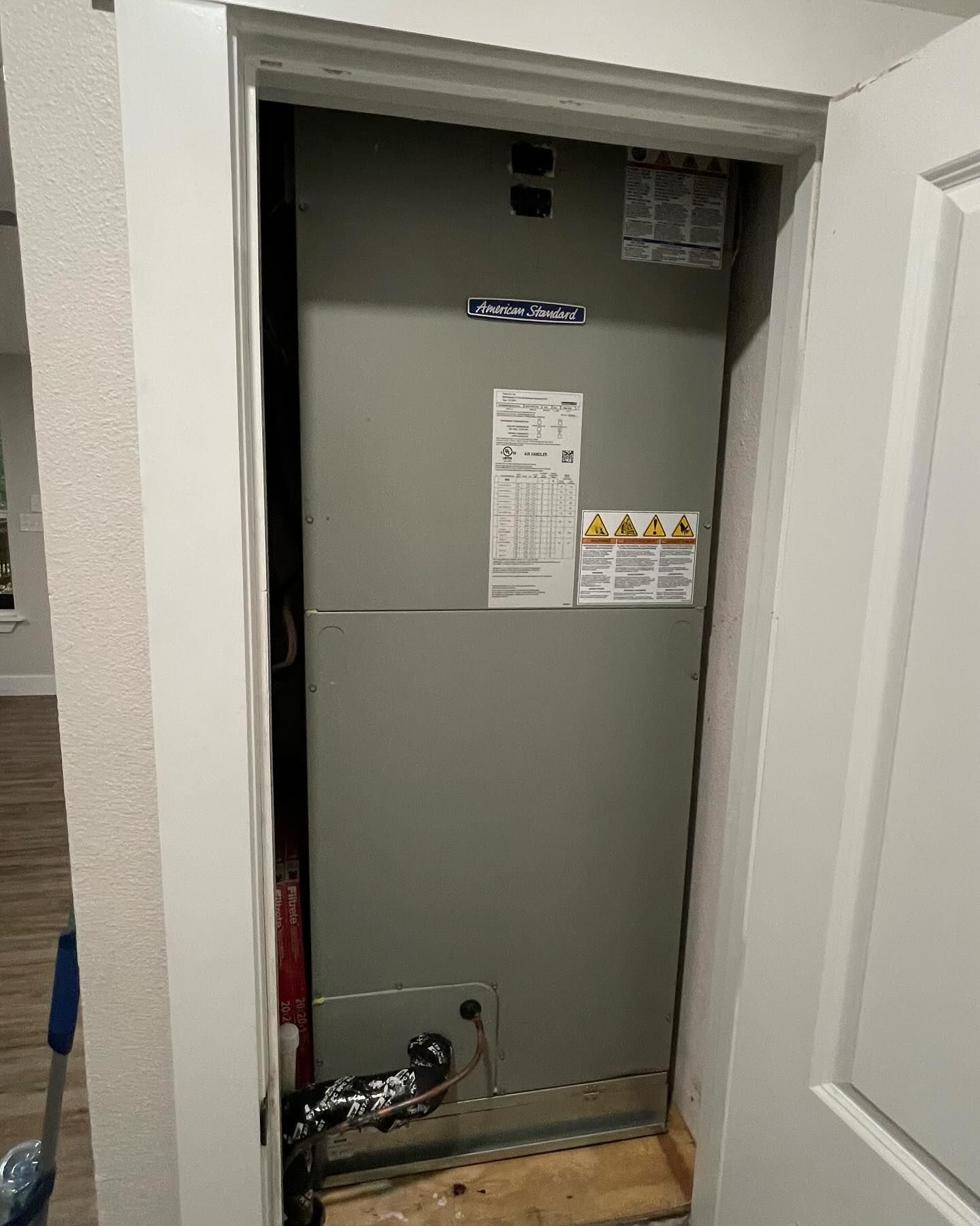 A large air conditioner is sitting inside of a doorway.