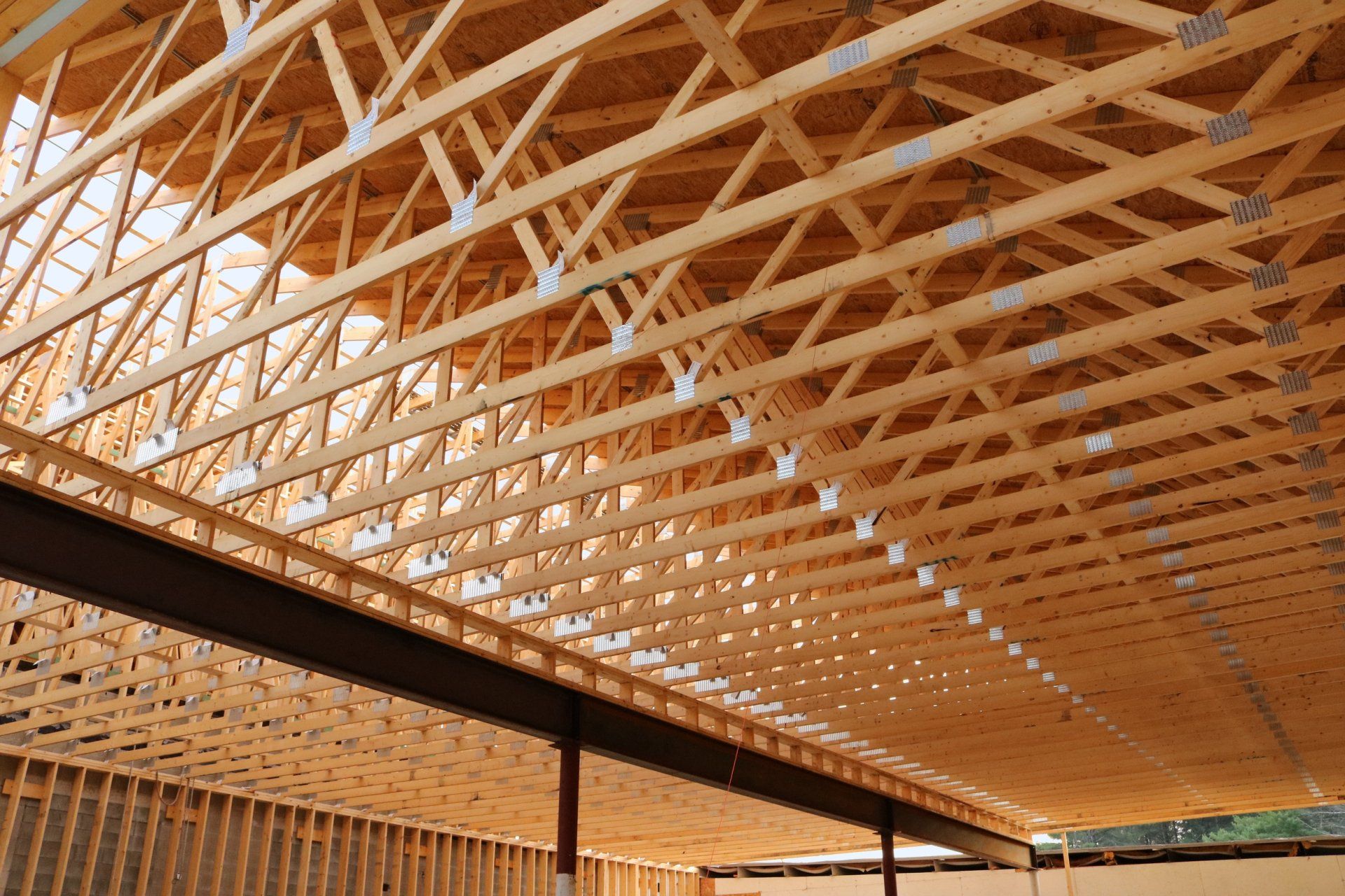 The ceiling of a building under construction is made of wooden beams.
