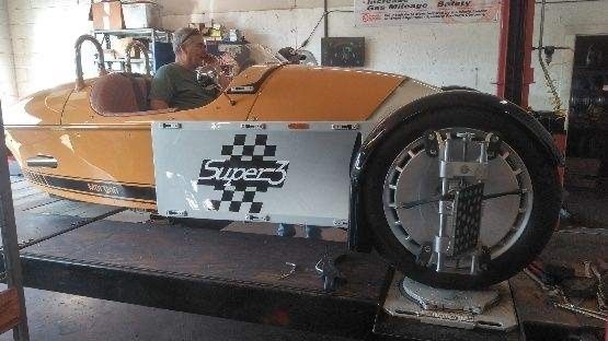 A man is sitting in the driver 's seat of a supercar