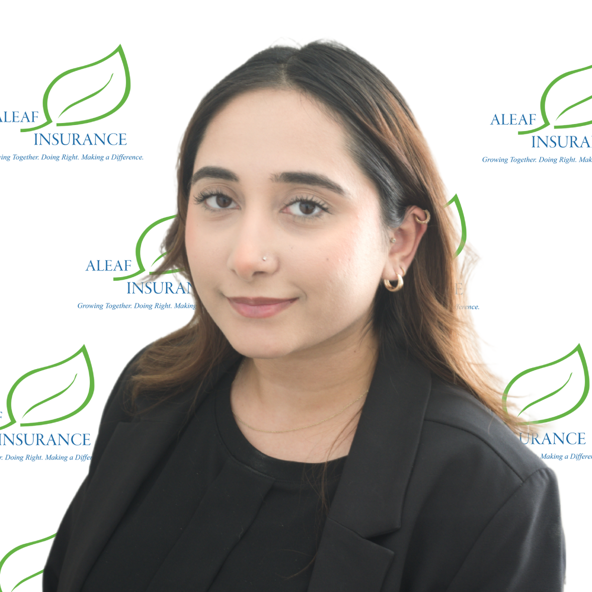 Woman with brown hair wearing a blazer, posing. The background features a company logo.
