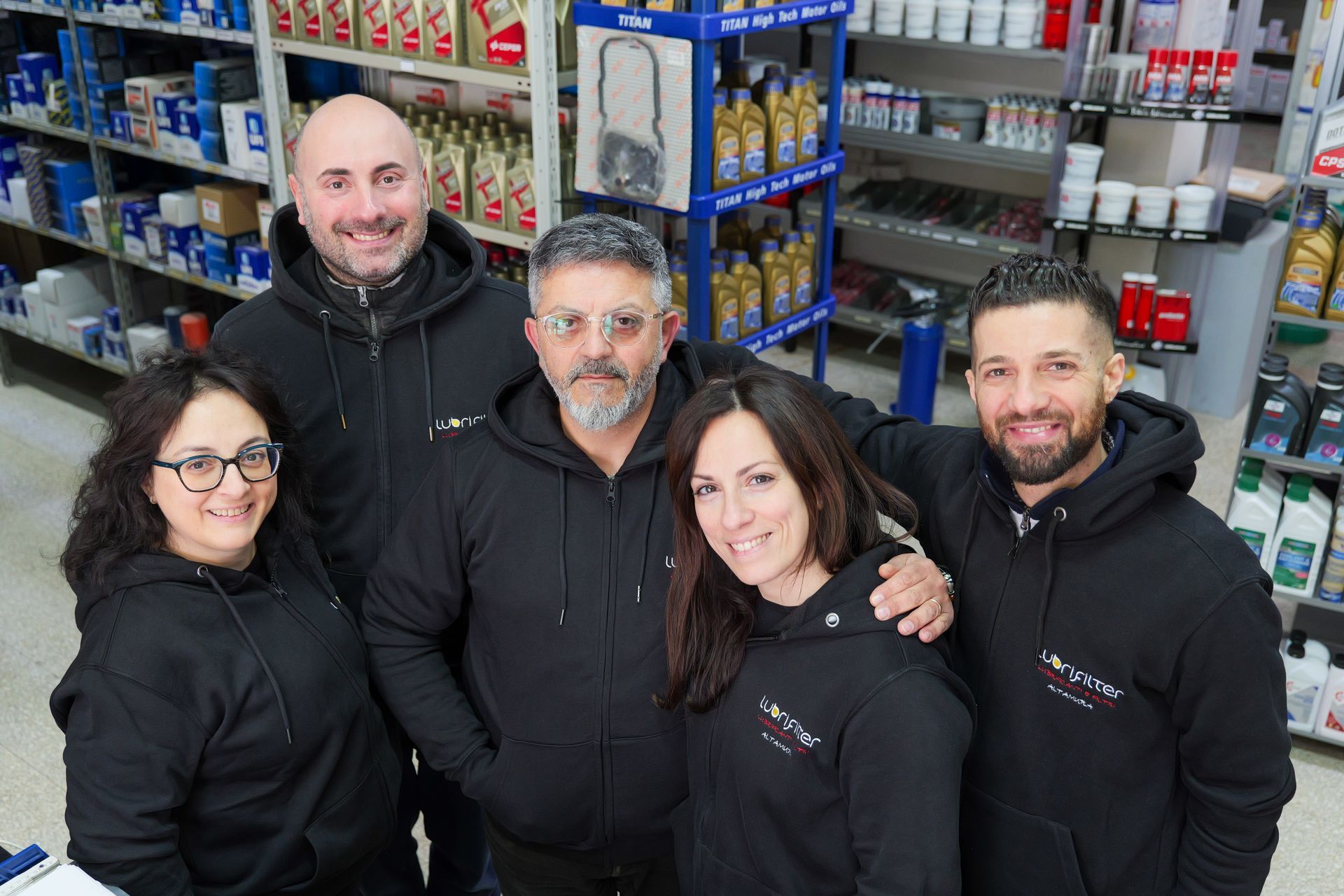 Due uomini in giacca e cravatta tengono in mano un premio. Uno di loro porge una targa all'altro, davanti al logo della Shell.